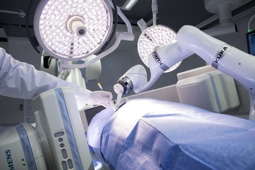 A robot places a needle at the incision site of a biopsy.