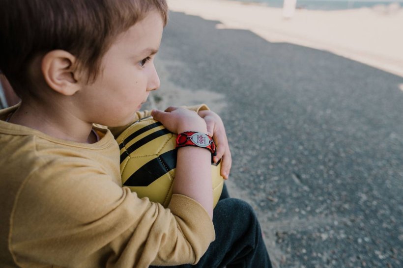 boy holding football wearing medical emergency wristband