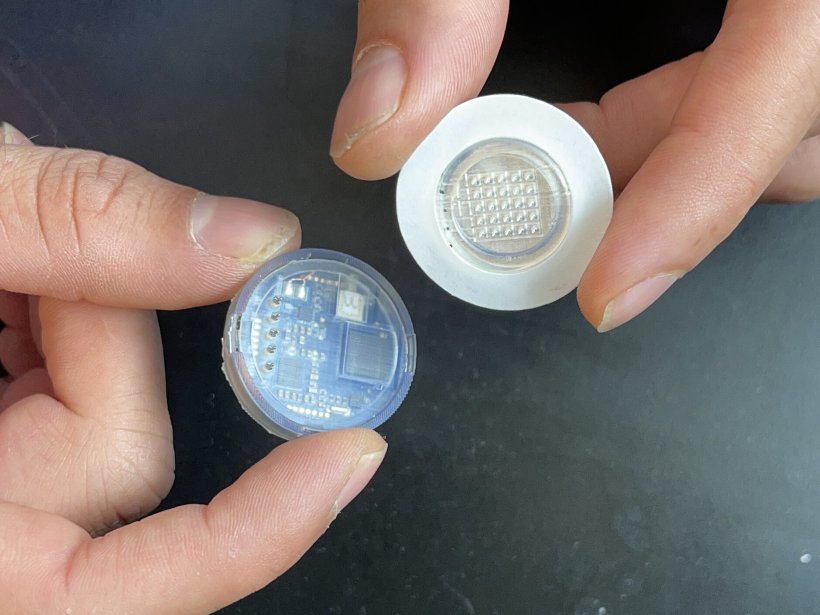 The disposable microneedle patch detaches from the reusable electronic case.