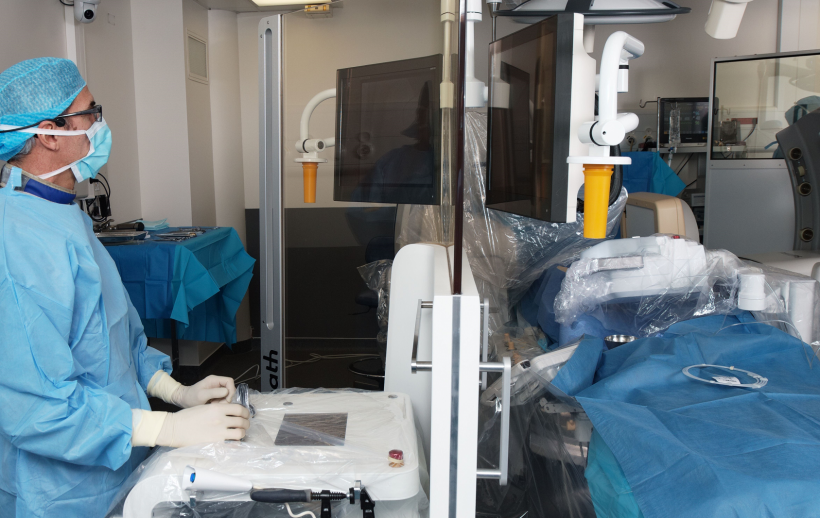 A glass shield protects the cardiologist from harmful radiation.