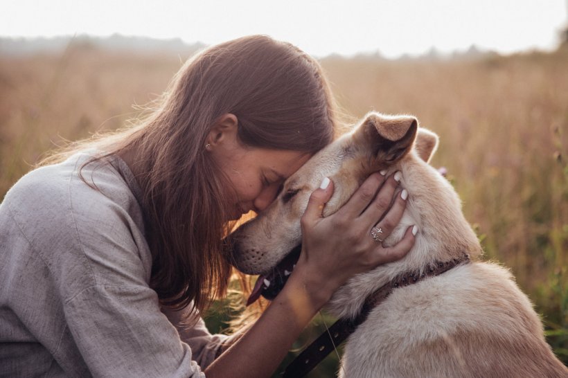 young woman hugging her dog