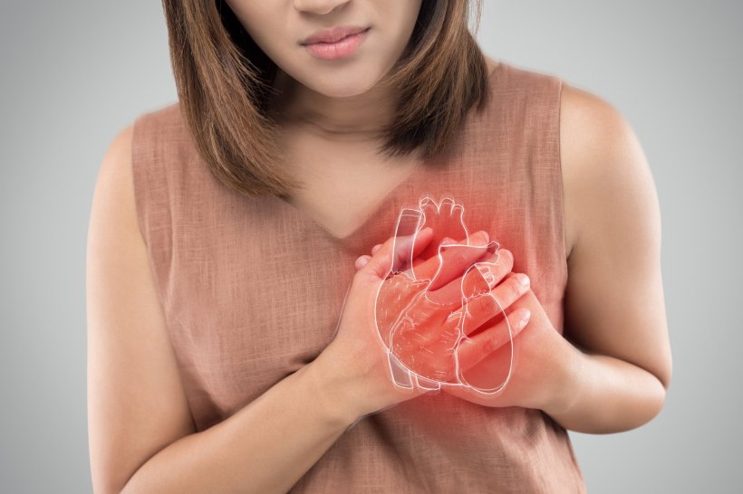 woman holding her heart in pain, infarction, heart attack