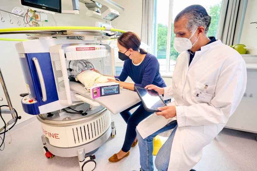 PD Dr. Hemmen Sabir untersucht ein Neugeborenes mit dem mobilen MRT und erhält...