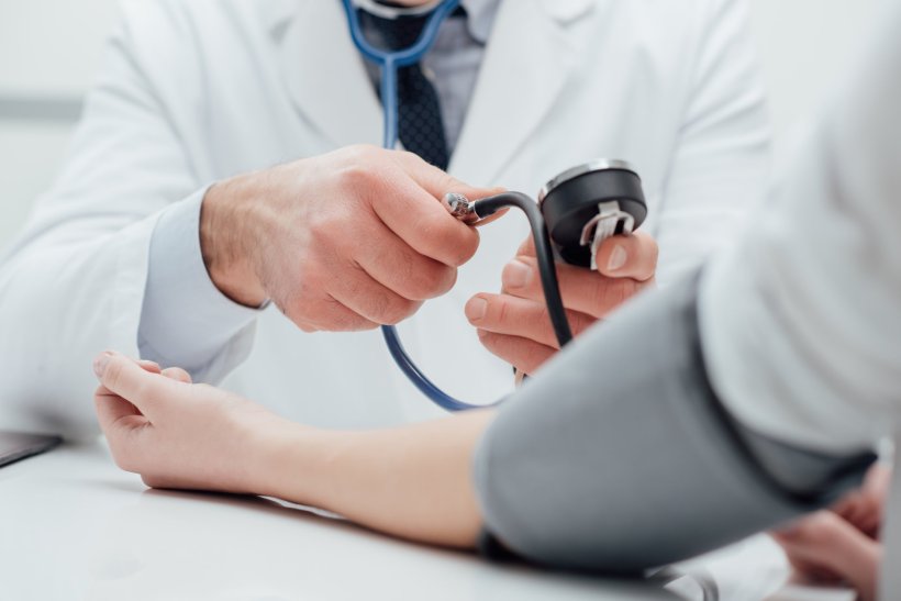 doctor measuring blood pressure on patient