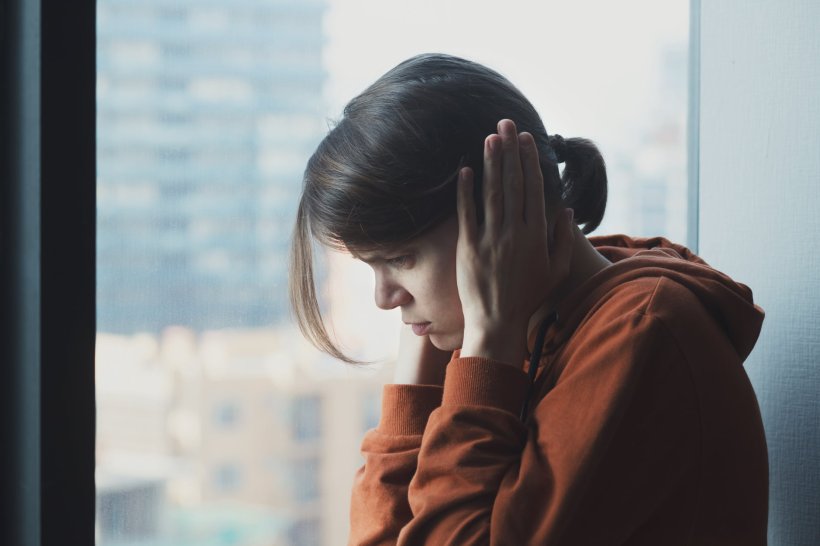 frustrated angry young woman covering her ears for noise protection