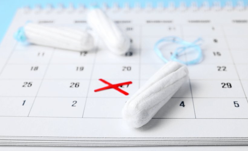 tampons on top of mentrual calendar, with a date marked with a red X
