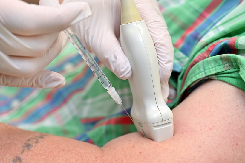 closeup photo of medical injection with ultrasound probe for control