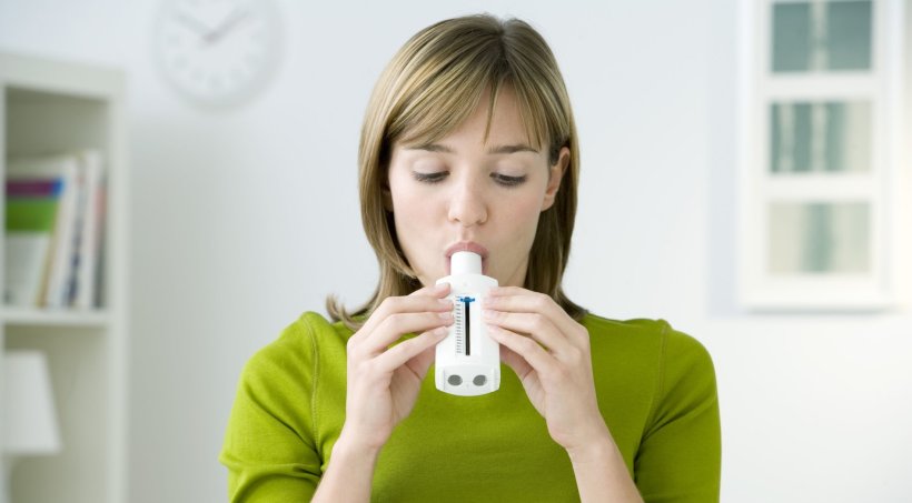 woman in green shirt performing spirometry lung test