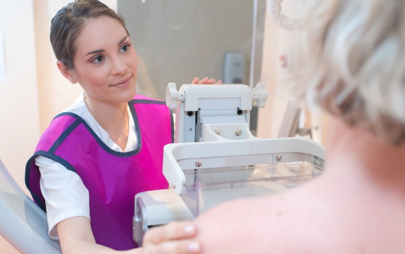young medical profesional performing mammography breast screening on older woman