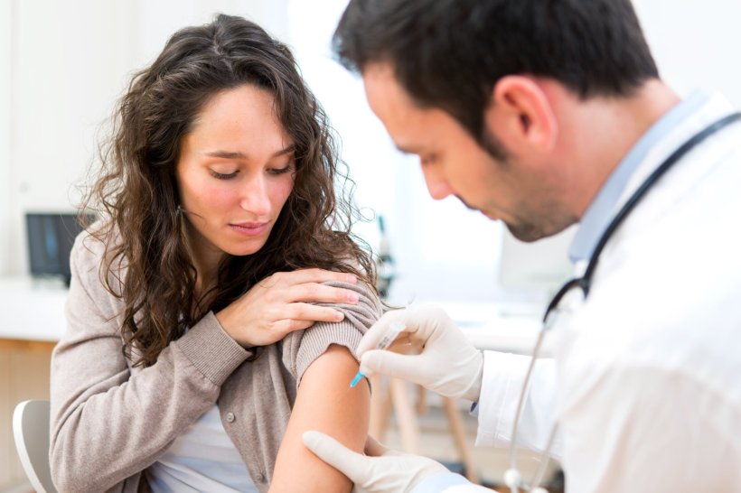 doctor administering vaccine injection to female patient