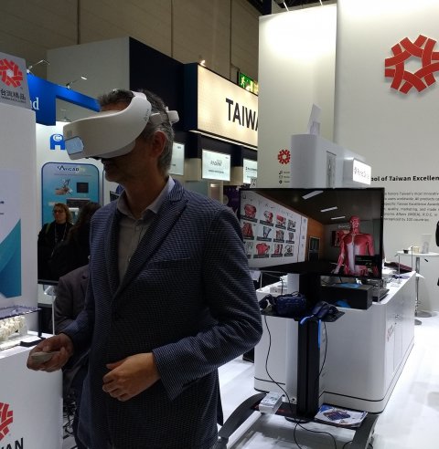 man with vr glasses exploring 3d anatomical model at medical fair