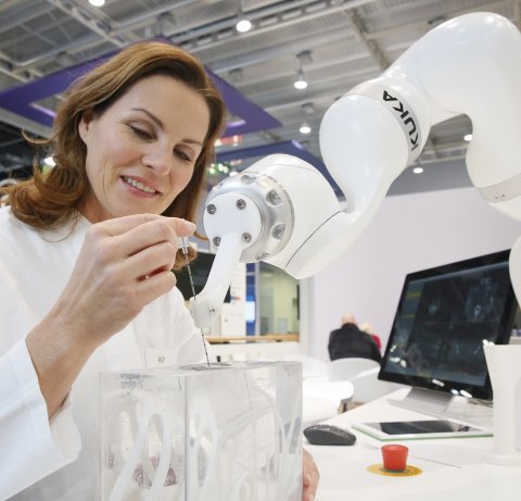 woman interacting with robotic arm