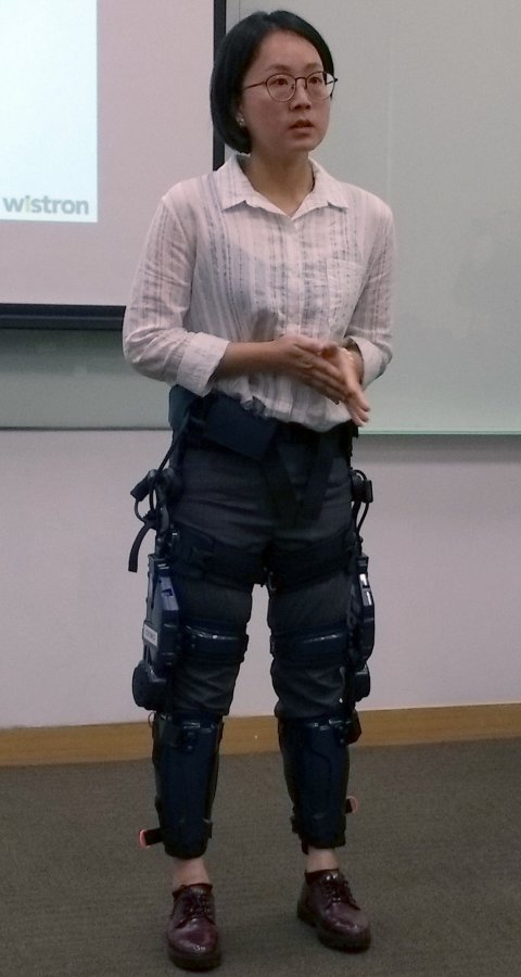 woman with robotic exoskeleton standing next to man in business suit