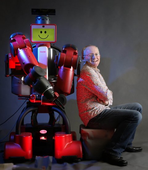 Toby Walsh squatting next to robot baxter