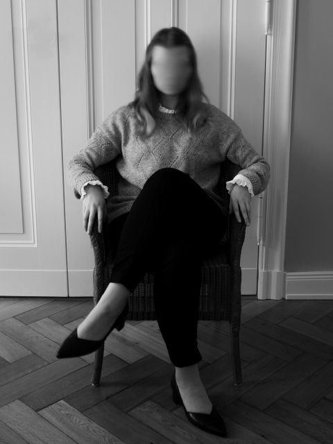 woman with blurry face sitting in a chair