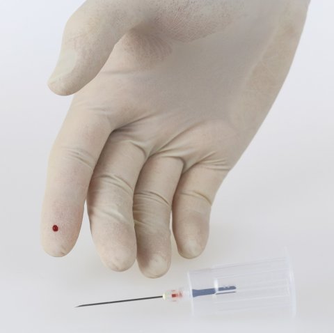 hand in medical glove with needlestick injury