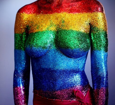 female body covered in rainbow-colored glitter stripes