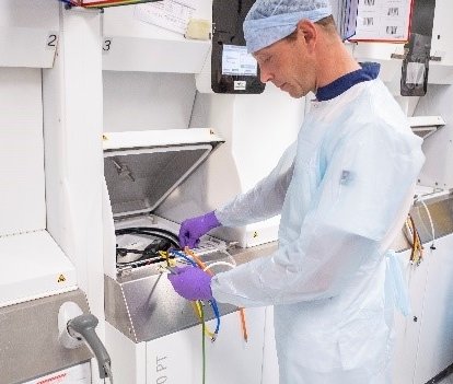person in white lab coat cleaning duodenoscope equipment
