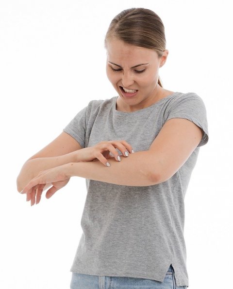woman scratching an itch on her arm
