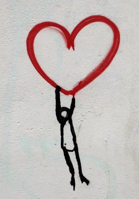 drawing of stickman hanging on to red heart