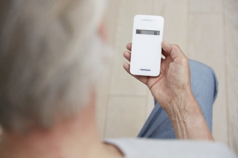 Older Person holding a Monitoring device