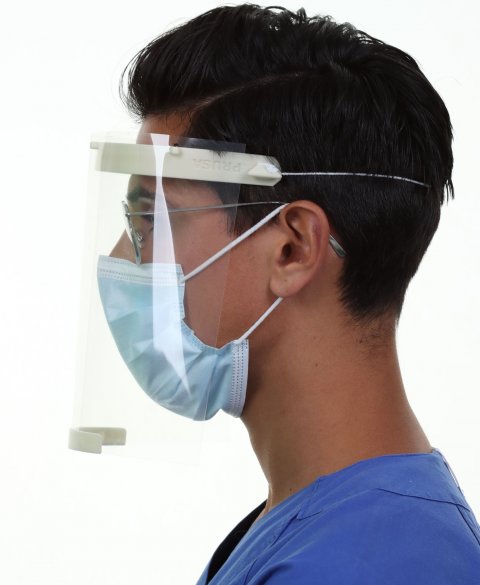 person wearing facemask and protective shield