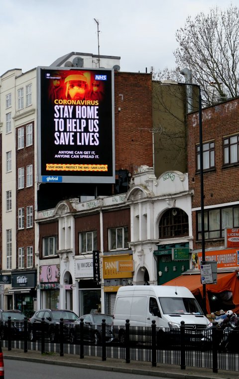 NHS billboard at crowded street