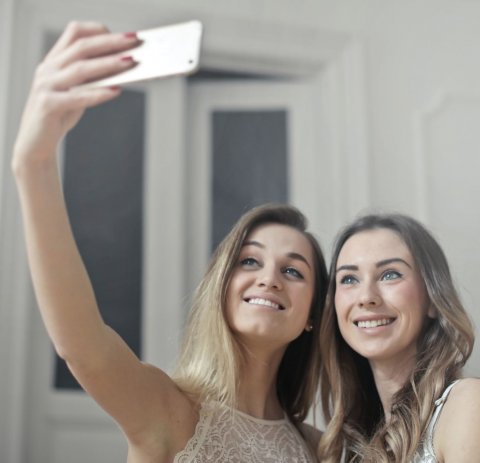 two women taking selfie with smartphone