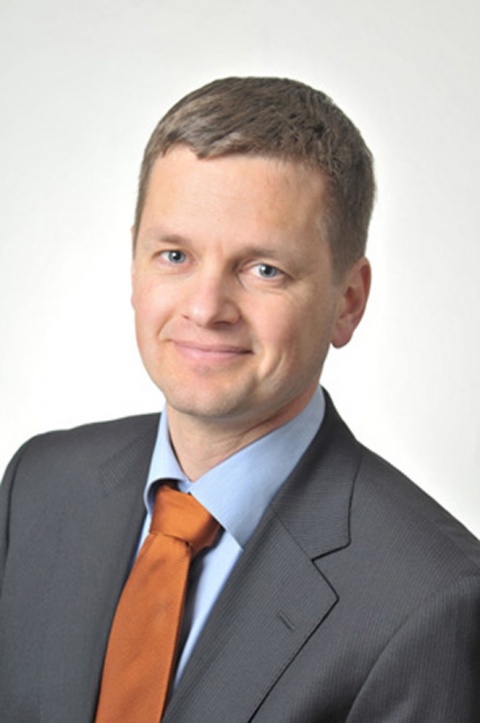 Professor Stephan Achenbach wears a grey jacket and a n brown tie