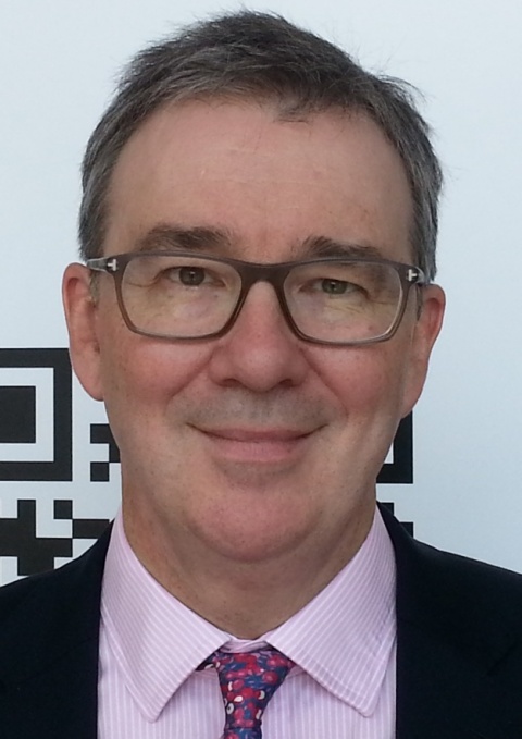 A smiling Prof Cliff Garratt wears glasses.