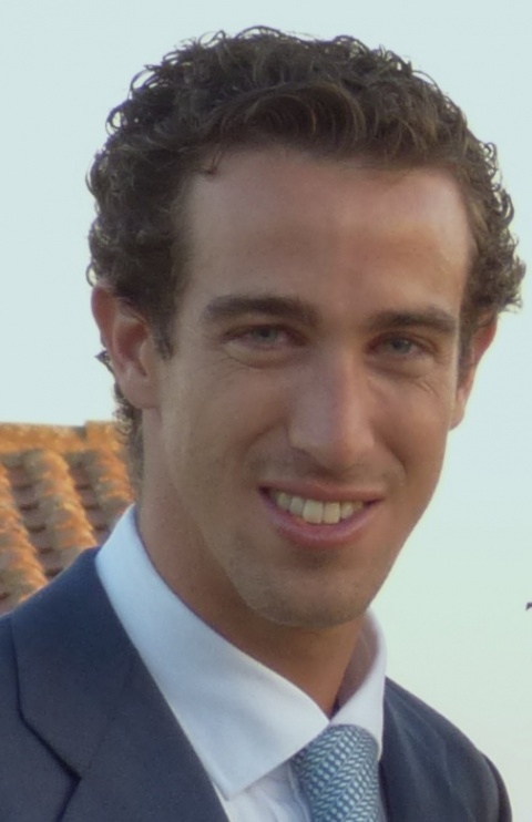 A smiling Daniel Rodriguez-Muñoz wears a white shirt with a blue tie.