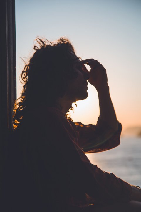 silhouette of woman holding her forehead from headache, migraine