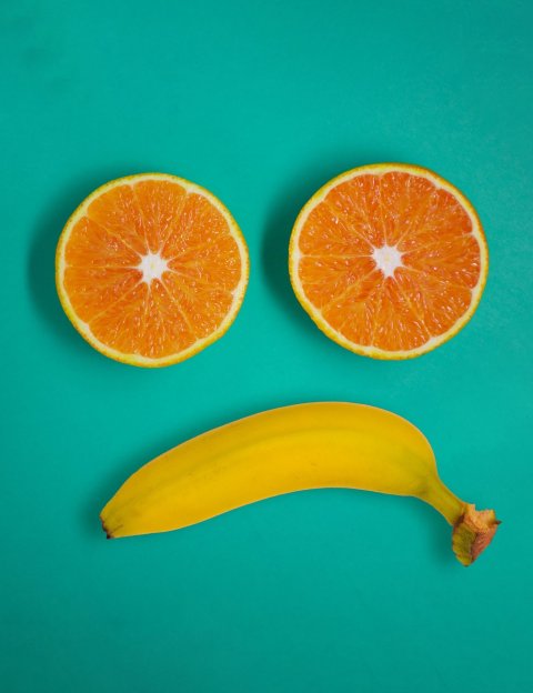 two orange slices and banana forming unhappy face :(