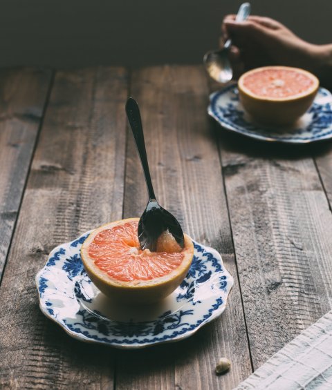 Grapefruit on wooden table with spoon