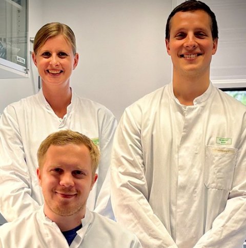 Alexander Brückner, Sarah Rieck und Adrian Brandtner sitzen gemeinsam in einem medizinischen Labor
