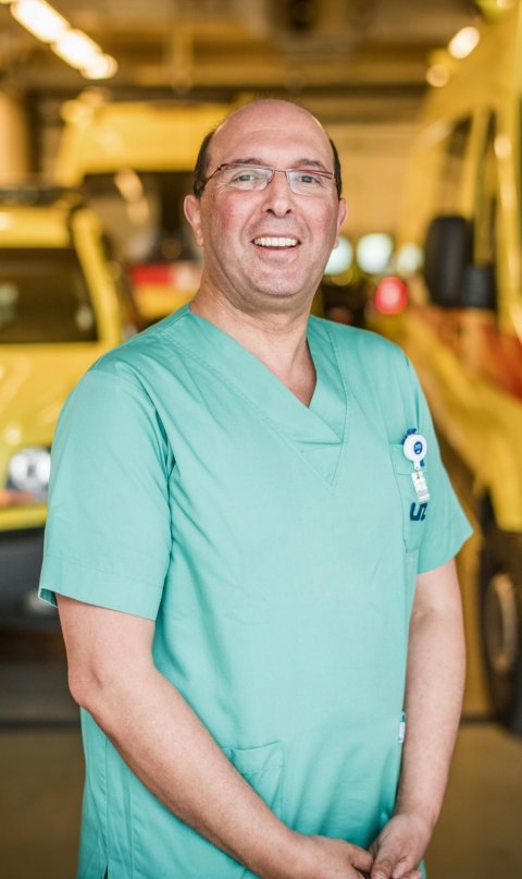 Dr Said Hachimi-Idrissi standing in front of ambulances in a hospital garage