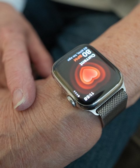 A smartwatch showing heart health data on a woman's arm