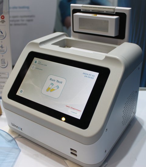 A small laboratory sample analyzer on display at a medical technology expo