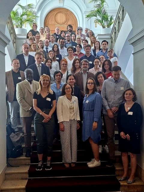 Ein Gruppenfoto mit 51 Personen, die sich auf einer Treppe aufgestellt haben