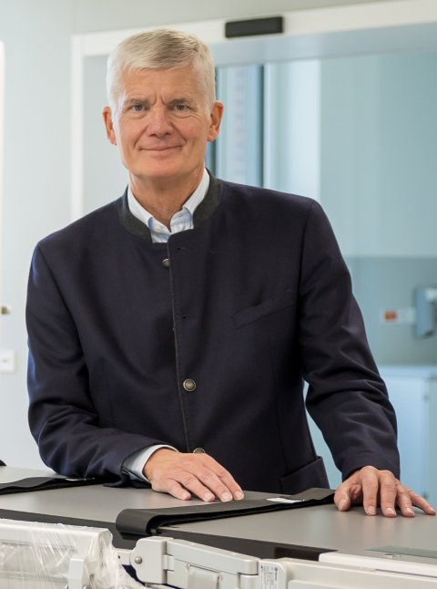 Prof. Dr. Dr. Hermann Reichenspurner steht hinter dem Tische eines medizinischen bildgebenden Systems