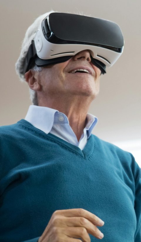 An elderly man wearing a virtual reality headset