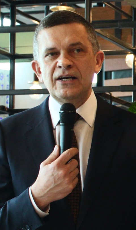 Sasa Mutic is speaking at a healthcare meeting, holding a microphone