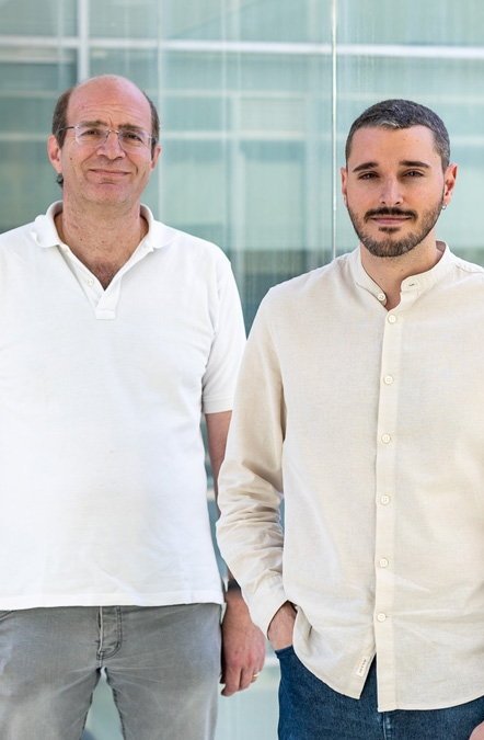 Vicente Traver and Salvador Borja are standing next to each other in a corridor hallway