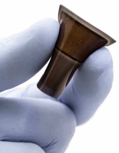 Closeup photo of a small sensor held by a hand in a protective glove