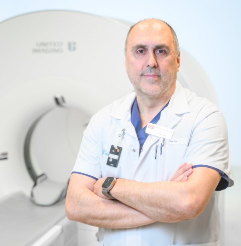Prof. dr. Koen Van Laere is standng in front of a PET/CT imaging scanner
