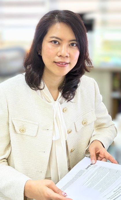 Prof. Yi-Fang Chang sitting at a computer desk with a scientific manuscript paper in her hands