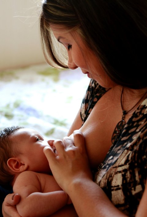 A mother is breastfeeding her newborn baby