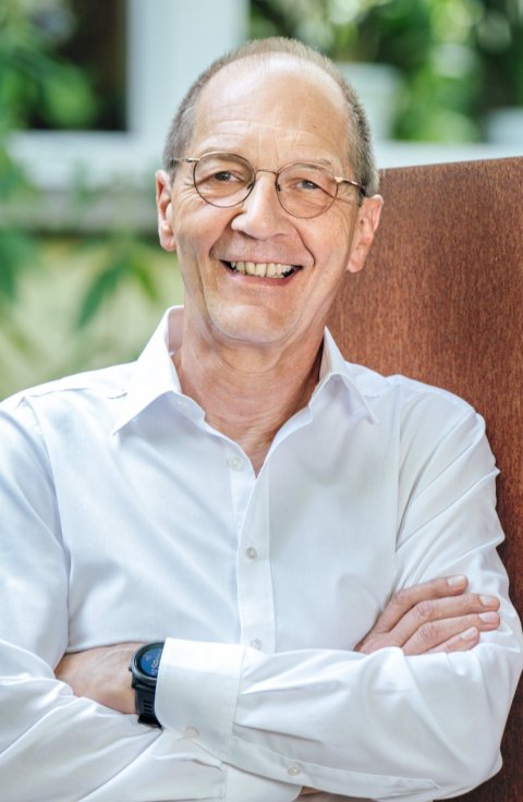 Dr. Torsten Möller lehnt an einem rostigen Metalltor, in das der Schriftzug reif & möller diagnostic network ag eingefräst ist