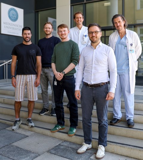Sechs Personen stehen für ein Teamfoto auf der Vortreppe einer Klinik