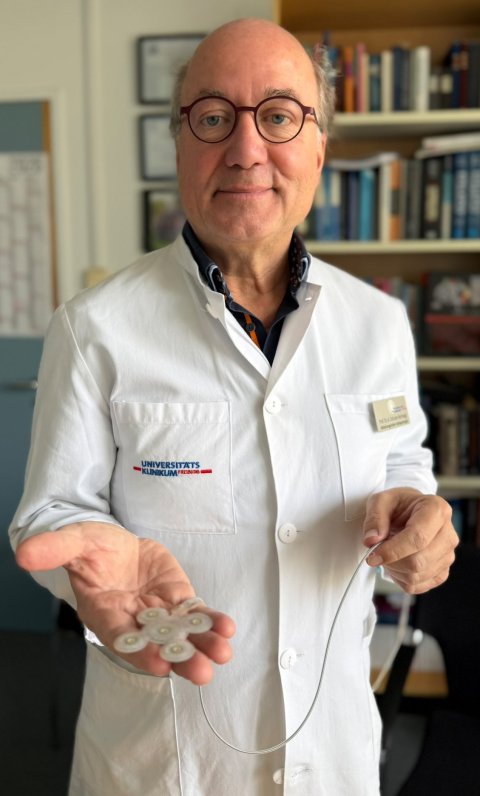 Prof. Andreas Schulze-Bonhage hält die Elektroden eines Hirnschrittmachers in die Kamera